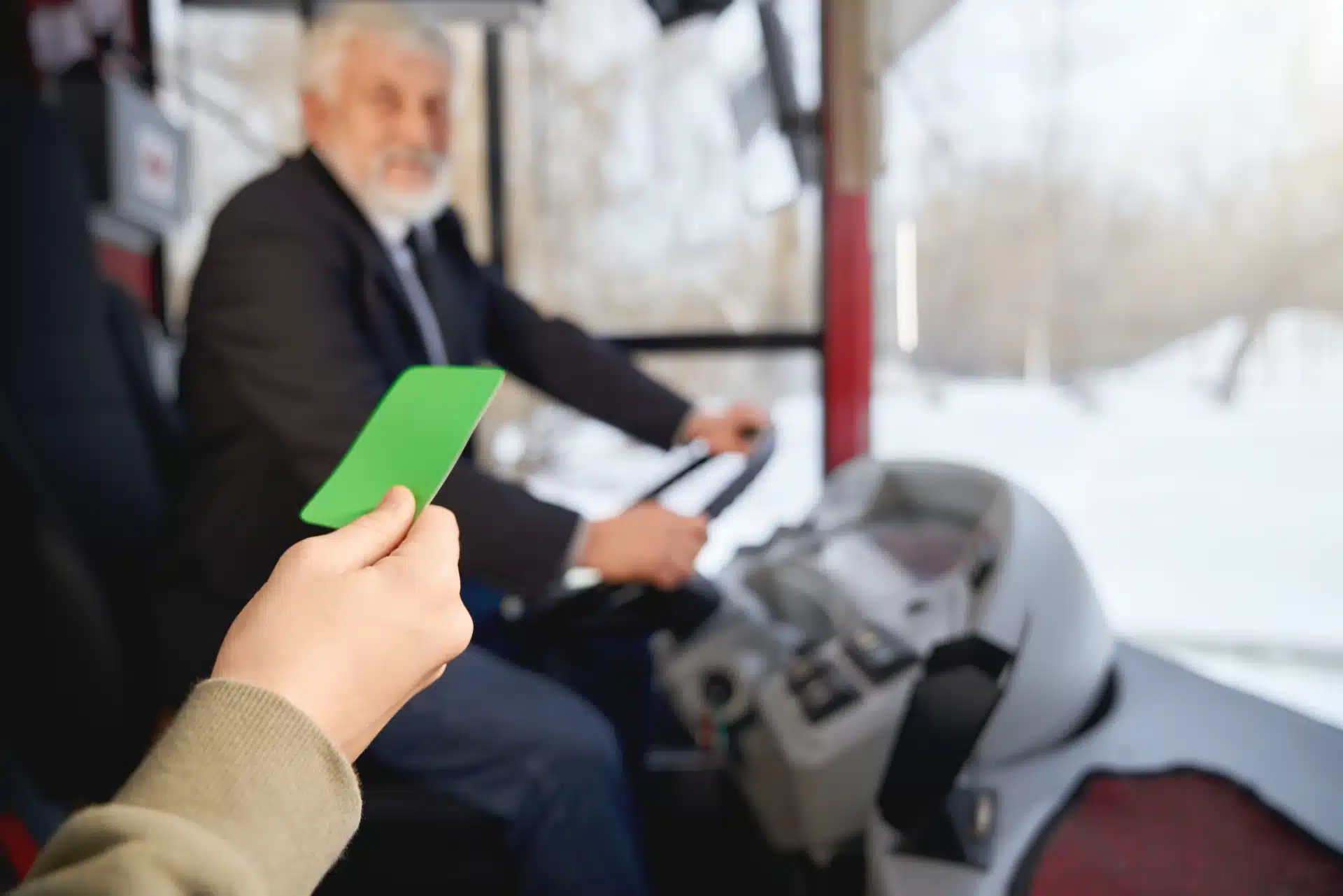 Pessoa apresentando um cartão verde ao motorista, enquanto entra em um ônibus